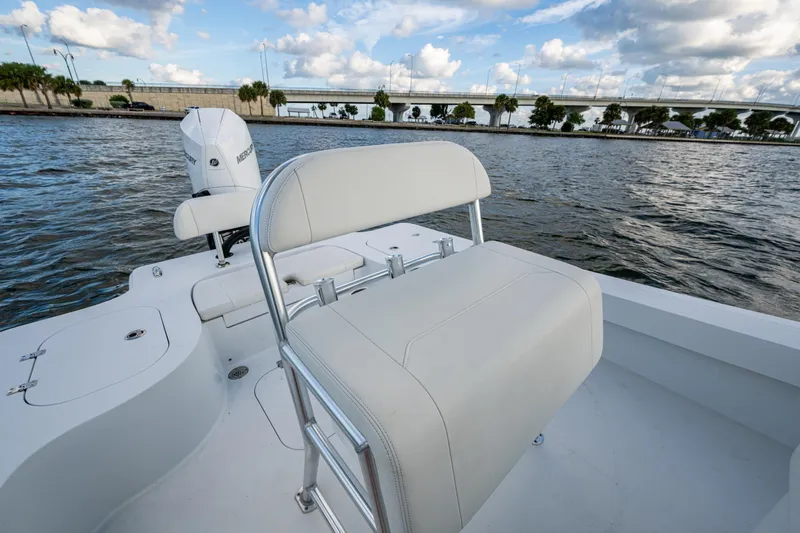  Yacht Photos Pics 2022 Conch 25 boat with white seating, on a scenic waterway under a cloudy sky.