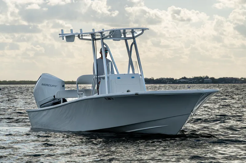  Yacht Photos Pics 2022 Conch 25 boat on water with Mercury engine, under cloudy sky.