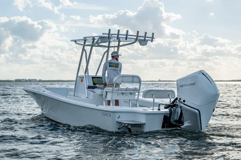  Yacht Photos Pics 2022 Conch 25 boat on water with Mercury engine, clear sky background.
