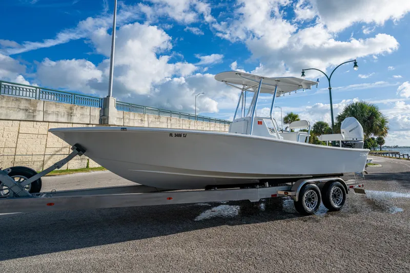  Yacht Photos Pics 2022 Conch 25 boat on trailer under blue sky, ready for launch.