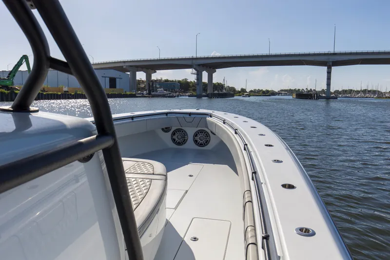 One More Yacht Photos Pics 2022 Contender 44 ST boat cruising under a bridge on a sunny day.