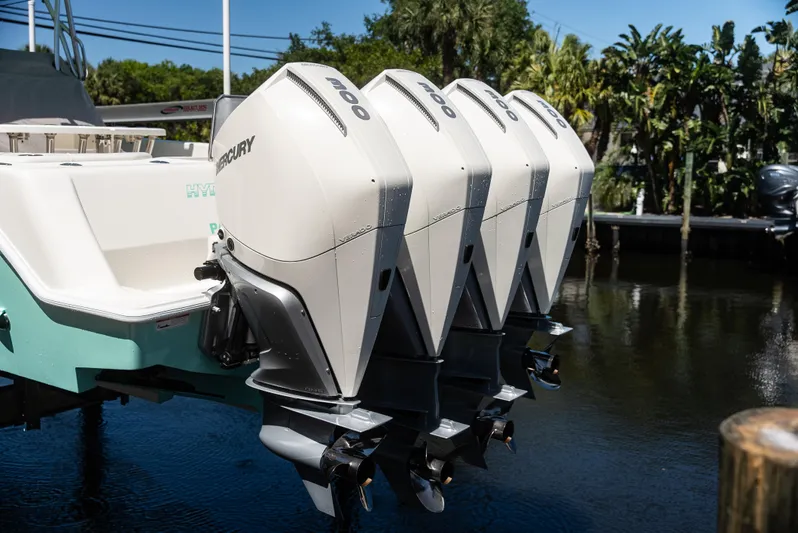  Yacht Photos Pics Four Mercury outboard engines on a 2022 SeaVee 390Z boat, docked by lush greenery.