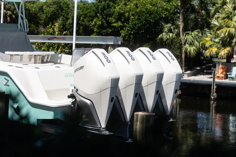  Yacht Photos Pics 2022 SeaVee 390Z boat with four Mercury outboard engines docked by lush greenery.