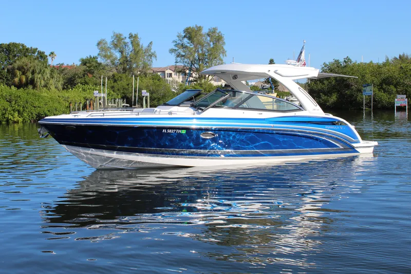  Yacht Photos Pics 2023 Formula 330 Crossover Bowrider on calm water, showcasing sleek design and vibrant blue color.