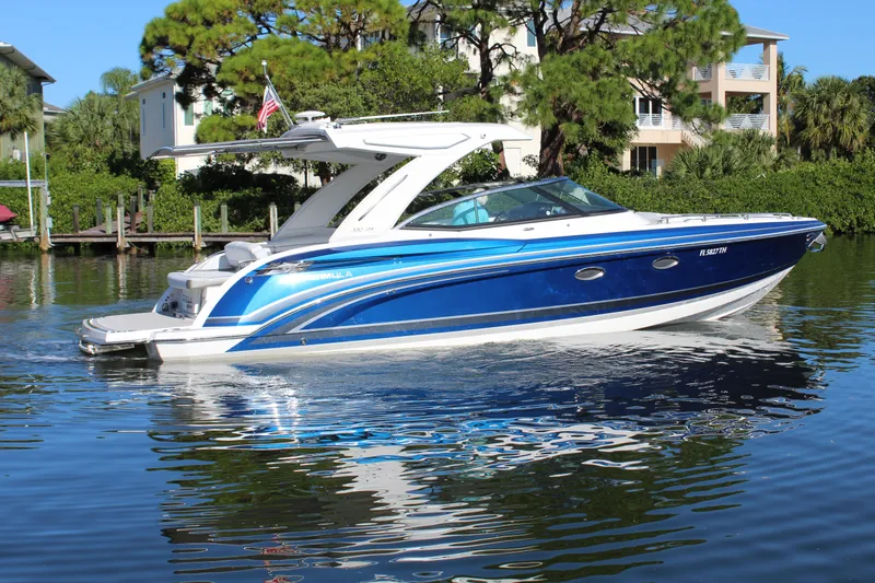  Yacht Photos Pics 2023 Formula 330 Crossover Bowrider in vibrant blue on a serene waterway.