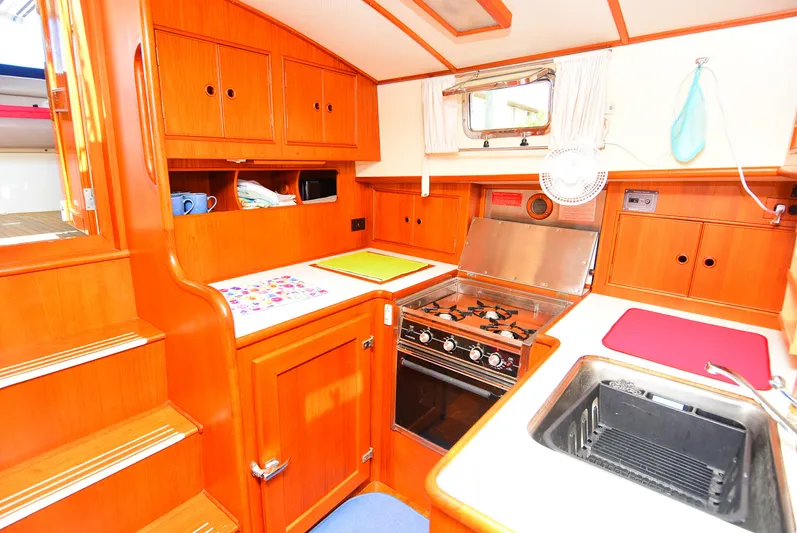  Yacht Photos Pics Galley kitchen in 1994 Grand Banks 38 Eastbay yacht with wood cabinetry and stove.