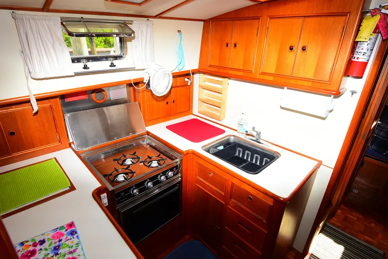  Yacht Photos Pics Cozy kitchen in 1994 Grand Banks 38 Eastbay yacht with stove, sink, and wooden cabinetry.