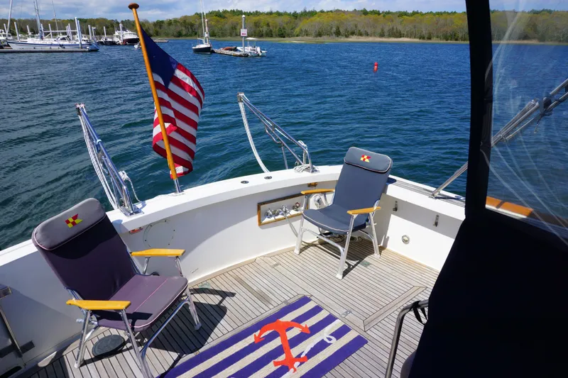  Yacht Photos Pics 1994 Grand Banks 38 Eastbay yacht deck with chairs, American flag, and scenic water view.