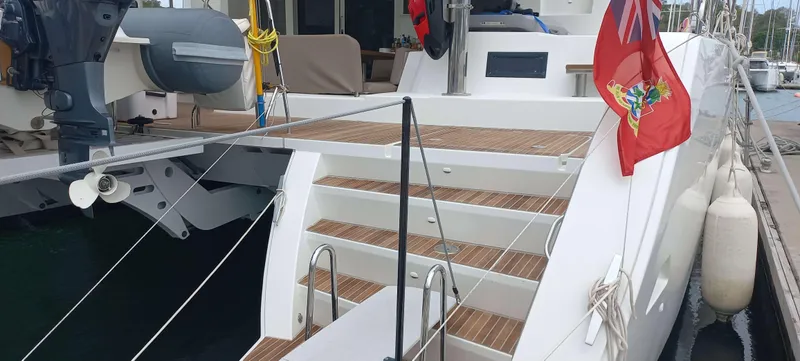 Amea Yacht Photos Pics 2014 Lagoon 52 F yacht with wooden deck, docked at marina, featuring a red flag.