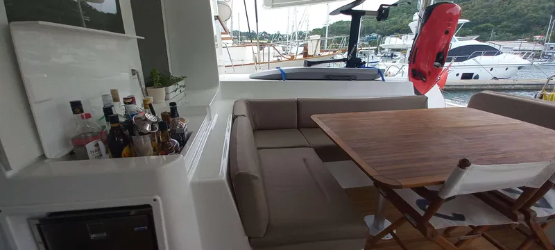 Amea Yacht Photos Pics Luxurious Lagoon 52 F yacht interior with seating, table, and bar setup, docked at marina.