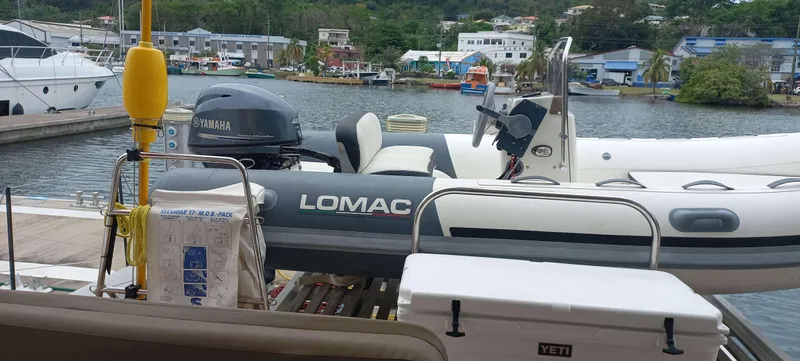 Amea Yacht Photos Pics Docked Lomac inflatable boat with Yamaha motor, near Lagoon 52 F, 2014 model, in a marina setting.