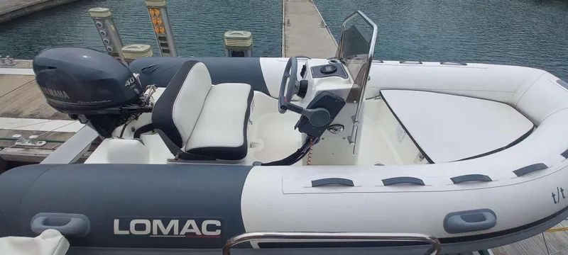 Amea Yacht Photos Pics A Lomac inflatable boat with Yamaha outboard motor docked at a marina.