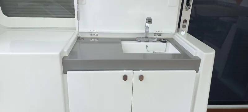 Amea Yacht Photos Pics Modern kitchen sink on 2014 Lagoon 52 F yacht, featuring sleek design and storage cabinets.