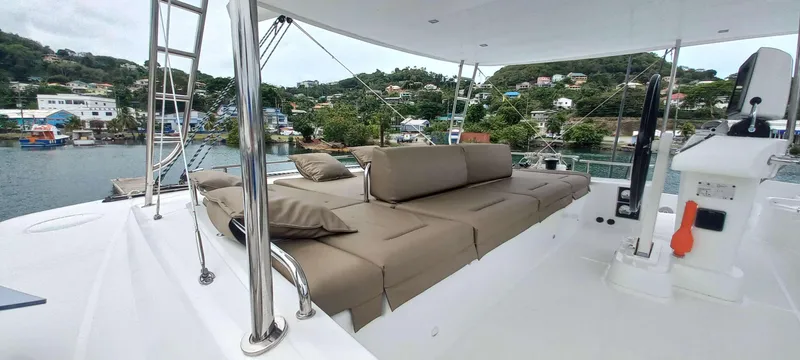 Amea Yacht Photos Pics Luxurious 2014 Lagoon 52 F catamaran deck with cushioned seating, overlooking scenic waterfront.