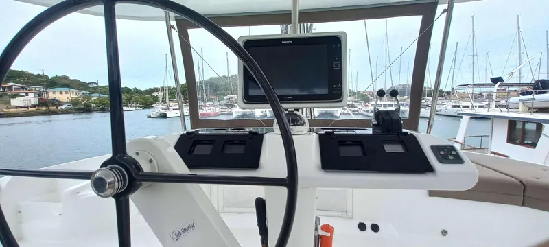 Amea Yacht Photos Pics Steering wheel and navigation system on a 2014 Lagoon 52 F catamaran in a marina.