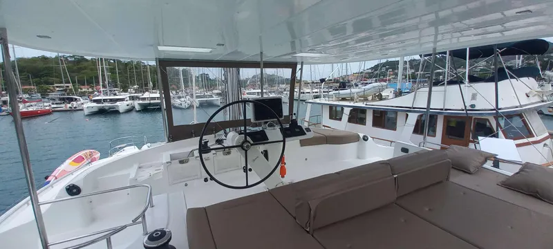 Amea Yacht Photos Pics Luxurious 2014 Lagoon 52 F yacht interior with steering wheel, docked in a marina.