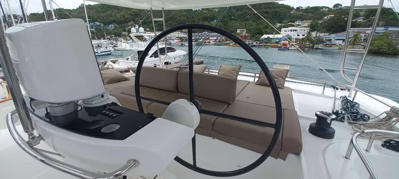 Amea Yacht Photos Pics 2014 Lagoon 52 F yacht helm with spacious seating, docked in a scenic marina.