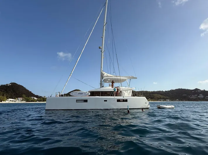Amea Yacht Photos Pics 2014 Lagoon 52 F catamaran sailing near scenic coastline.
