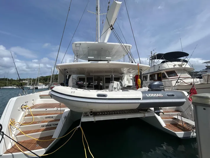 Amea Yacht Photos Pics 2014 Lagoon 52 F catamaran docked with tender boat, sunny marina background.