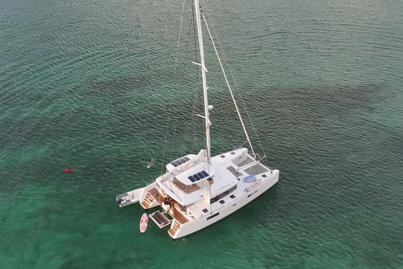 Amea Yacht Photos Pics Aerial view of 2014 Lagoon 52 F catamaran sailing on clear turquoise waters.