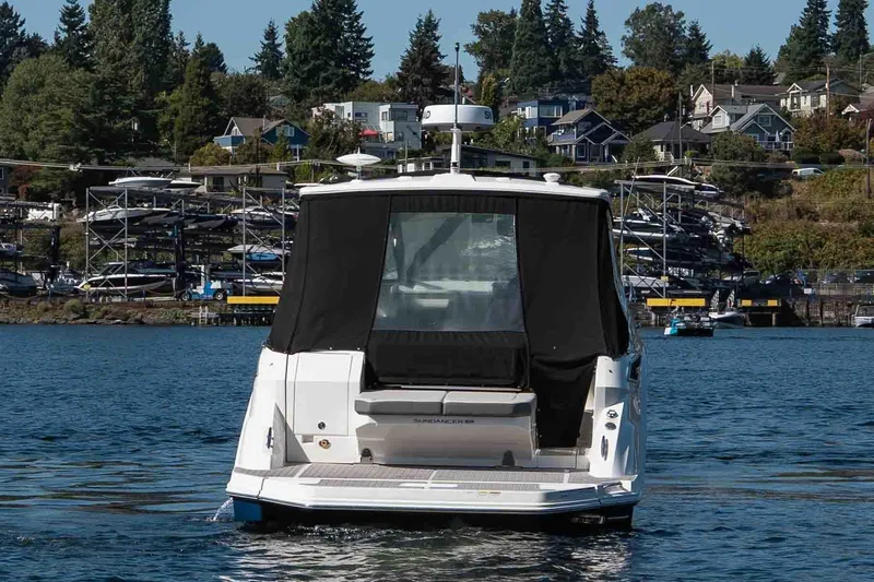  Yacht Photos Pics 2023 Sea Ray Sundancer 320 Coupe on water, with marina and houses in background.