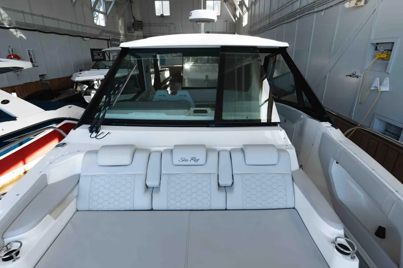  Yacht Photos Pics 2023 Sea Ray Sundancer 320 Coupe in a showroom, showcasing sleek design and luxury seating.