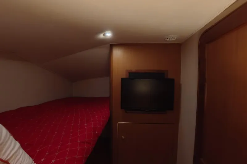 Never Been Fished Yacht Photos Pics Cozy cabin interior of 2002 Ocean Yachts 52 SS with red bedding and wall-mounted TV.