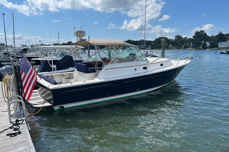  Yacht Photos Pics 2005 Hunt Yachts Surfhunter 33 docked in a marina, featuring a sleek design and American flag.