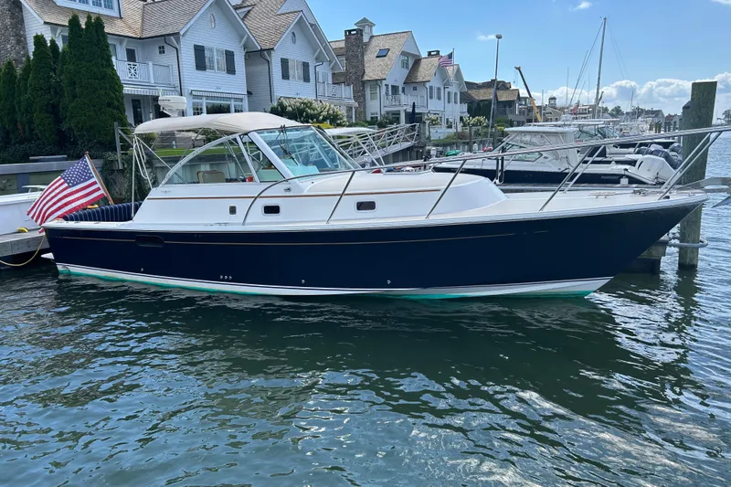 Yacht Photos Pics 2005 Hunt Yachts Surfhunter 33 docked near waterfront homes, displaying an American flag.