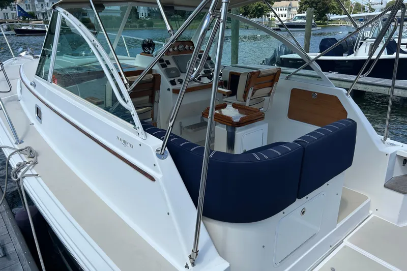 Yacht Photos Pics 2005 Hunt Yachts Surfhunter 33 cockpit with blue seating and helm, docked by the water.