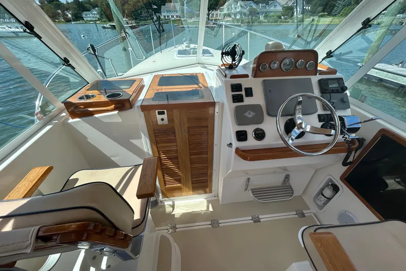  Yacht Photos Pics 2005 Hunt Yachts Surfhunter 33 cockpit with steering wheel, controls, and seating, docked by the water.