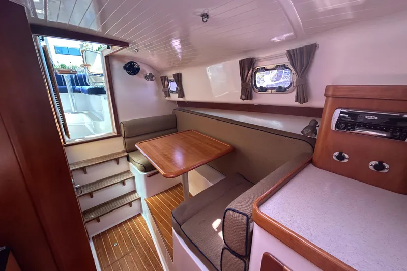  Yacht Photos Pics Interior of 2005 Hunt Yachts Surfhunter 33 with cozy seating and wooden table.