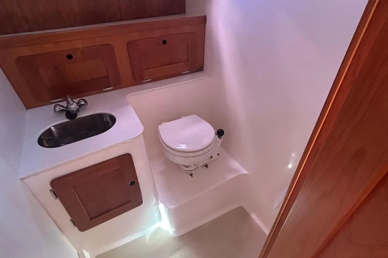 Yacht Photos Pics 2005 Hunt Yachts Surfhunter 33 bathroom with sink, toilet, and wooden cabinets.