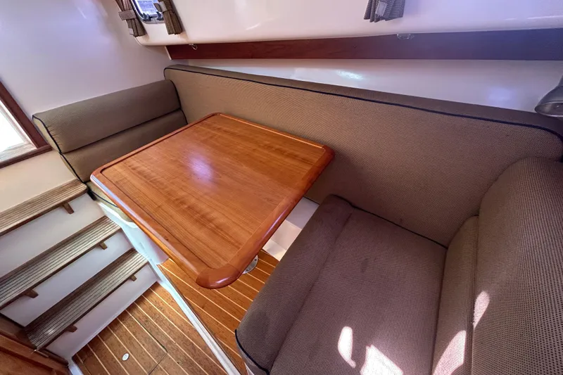  Yacht Photos Pics Interior of 2005 Hunt Yachts Surfhunter 33 with wooden table and cushioned seating.