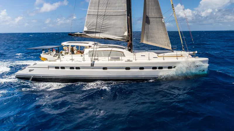 Orion Yacht Photos Pics Luxury Catana 90 catamaran sailing on open ocean, 2008 model, under clear blue skies.