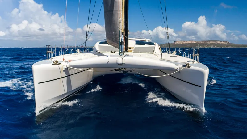 Orion Yacht Photos Pics Catana 90 catamaran sailing on open sea, 2008 model, under clear blue skies.