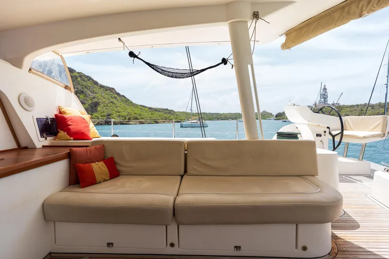 Orion Yacht Photos Pics Luxurious Catana 90 yacht interior with beige seating, colorful cushions, and scenic ocean view.