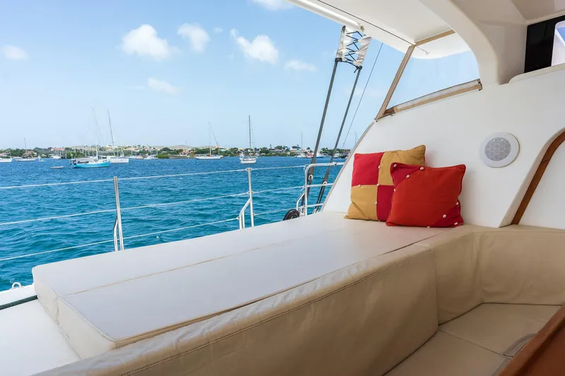 Orion Yacht Photos Pics Luxurious Catana 90 yacht interior with ocean view, featuring comfortable seating and colorful cushions.