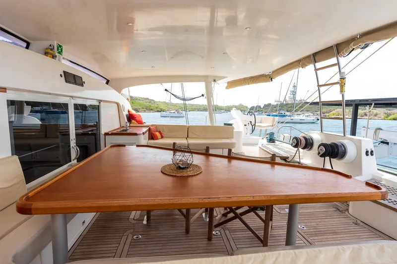 Orion Yacht Photos Pics Spacious deck of 2008 Catana 90 yacht with wooden table and scenic ocean view.