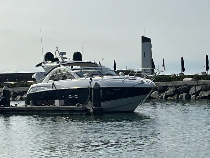  Yacht Photos Pics 2011 Sunseeker Portofino 48 yacht docked in a serene marina setting.