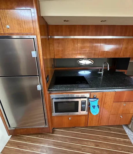  Yacht Photos Pics 2006 Cruisers Yachts 420 Express kitchen with wood cabinetry, stainless appliances, and granite countertop.