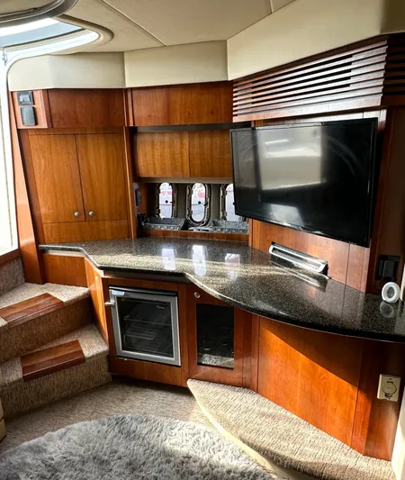  Yacht Photos Pics Interior of 2006 Cruisers Yachts 420 Express with TV, wood cabinetry, and carpeted steps.