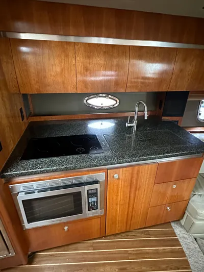  Yacht Photos Pics 2006 Cruisers Yachts 420 Express kitchen with wood cabinets, granite countertop, and modern appliances.