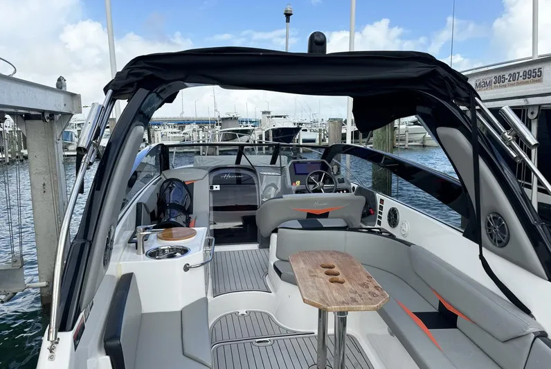  Yacht Photos Pics 2024 Hanover 305 boat interior with seating, table, and helm, docked at a marina.