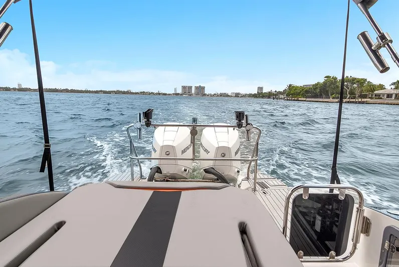  Yacht Photos Pics 2024 Hanover 305 boat cruising on open water with city skyline in background.