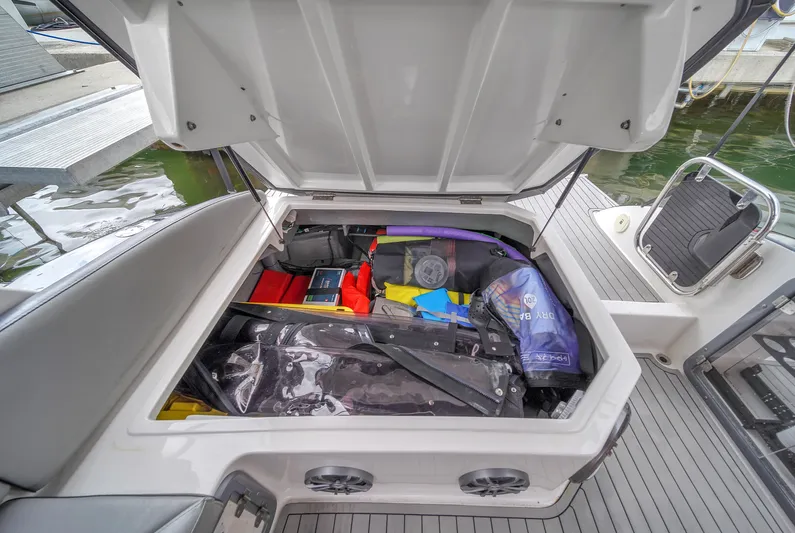  Yacht Photos Pics Open storage compartment on 2024 Hanover 305 boat, filled with various boating gear.