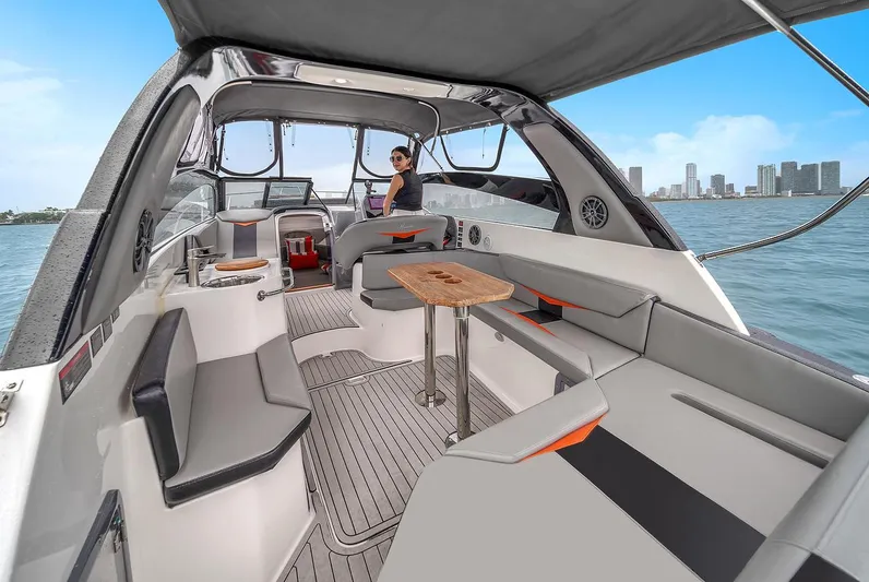  Yacht Photos Pics 2024 Hanover 305 boat interior with modern seating, table, and city skyline view.