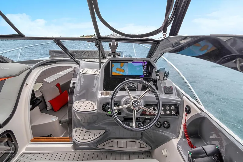  Yacht Photos Pics 2024 Hanover 305 boat cockpit with modern navigation system and steering wheel on open water.