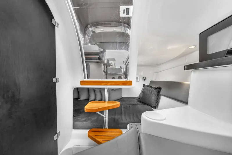 Yacht Photos Pics 2024 Hanover 305 boat interior with modern design, featuring wooden steps and cozy seating area.