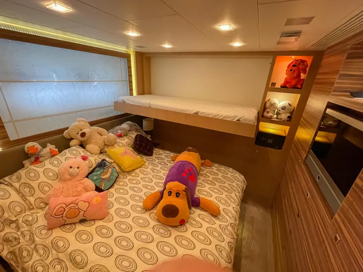 Espresso Yacht Photos Pics Cozy bedroom with plush toys on a bed, wooden accents, and soft lighting. Horizon 122, 2009.
